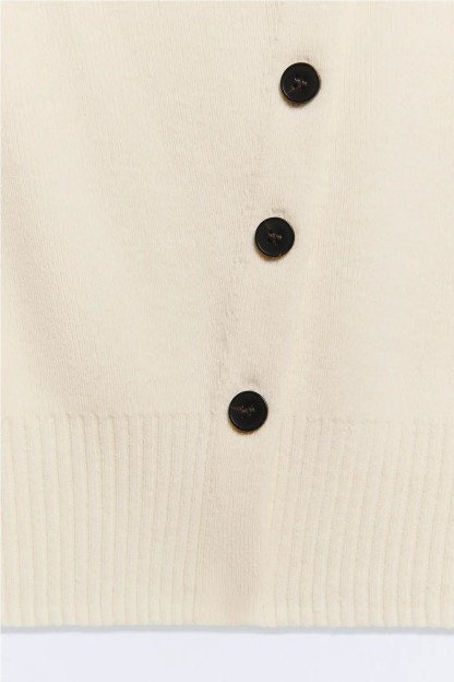 chaqueta blanca con botones asimetricos negros